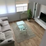 Salón reformado con suelo laminado y decoración moderna, reforma integral Ceymar