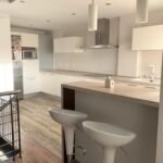 Reforma de cocina moderna con isla y taburetes, proyecto Ceymar en Ciudad Real