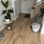 Recibidor reformado con suelo de tarima flotante y paredes revestidas en madera