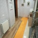 Pasillo reformado con suelo de tarima flotante y paredes revestidas en Ciudad Real