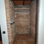 Trastero antes de reforma con paredes de ladrillo visto pendientes de acabado