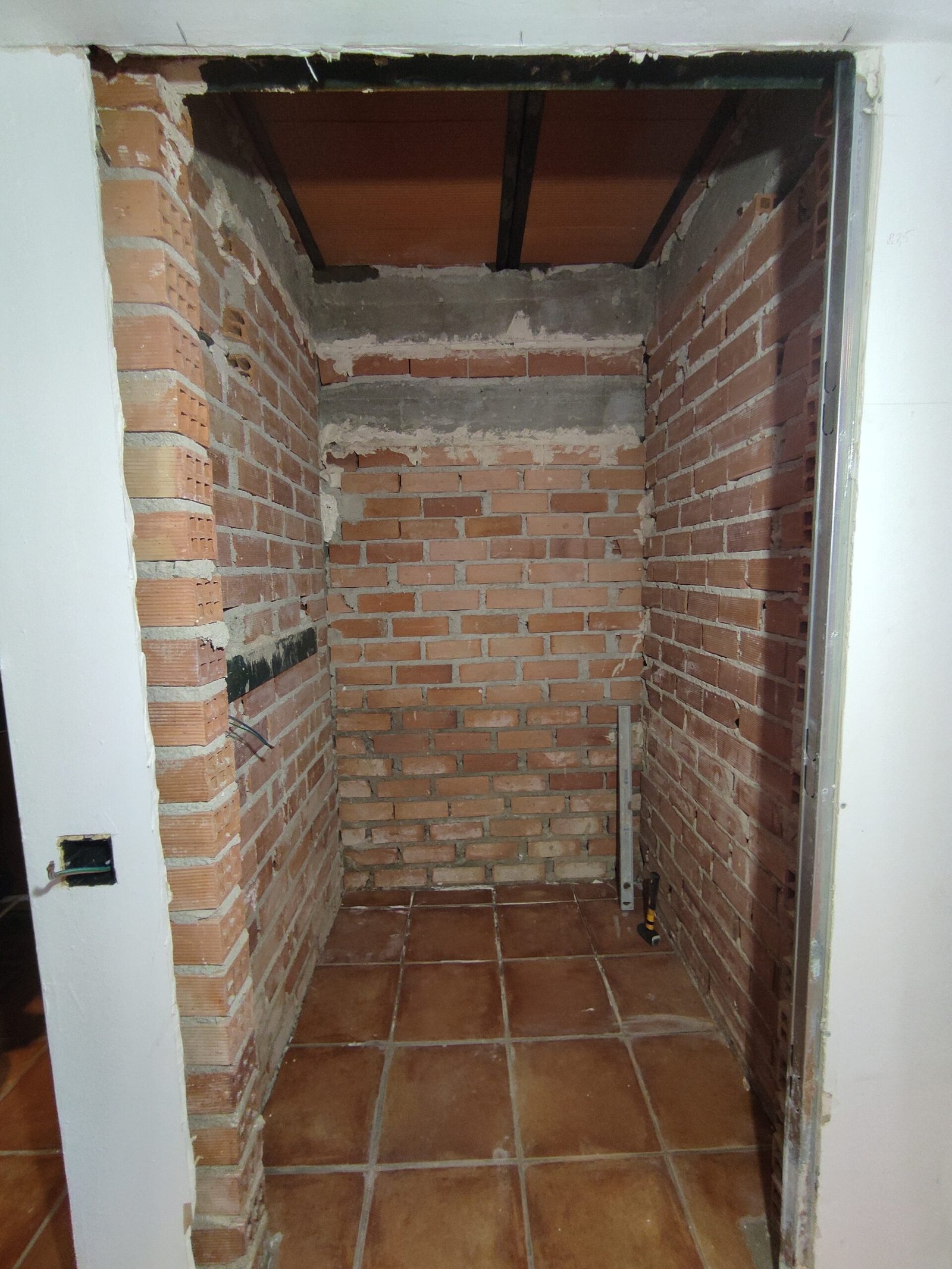 Trastero antes de reforma con paredes de ladrillo visto pendientes de acabado